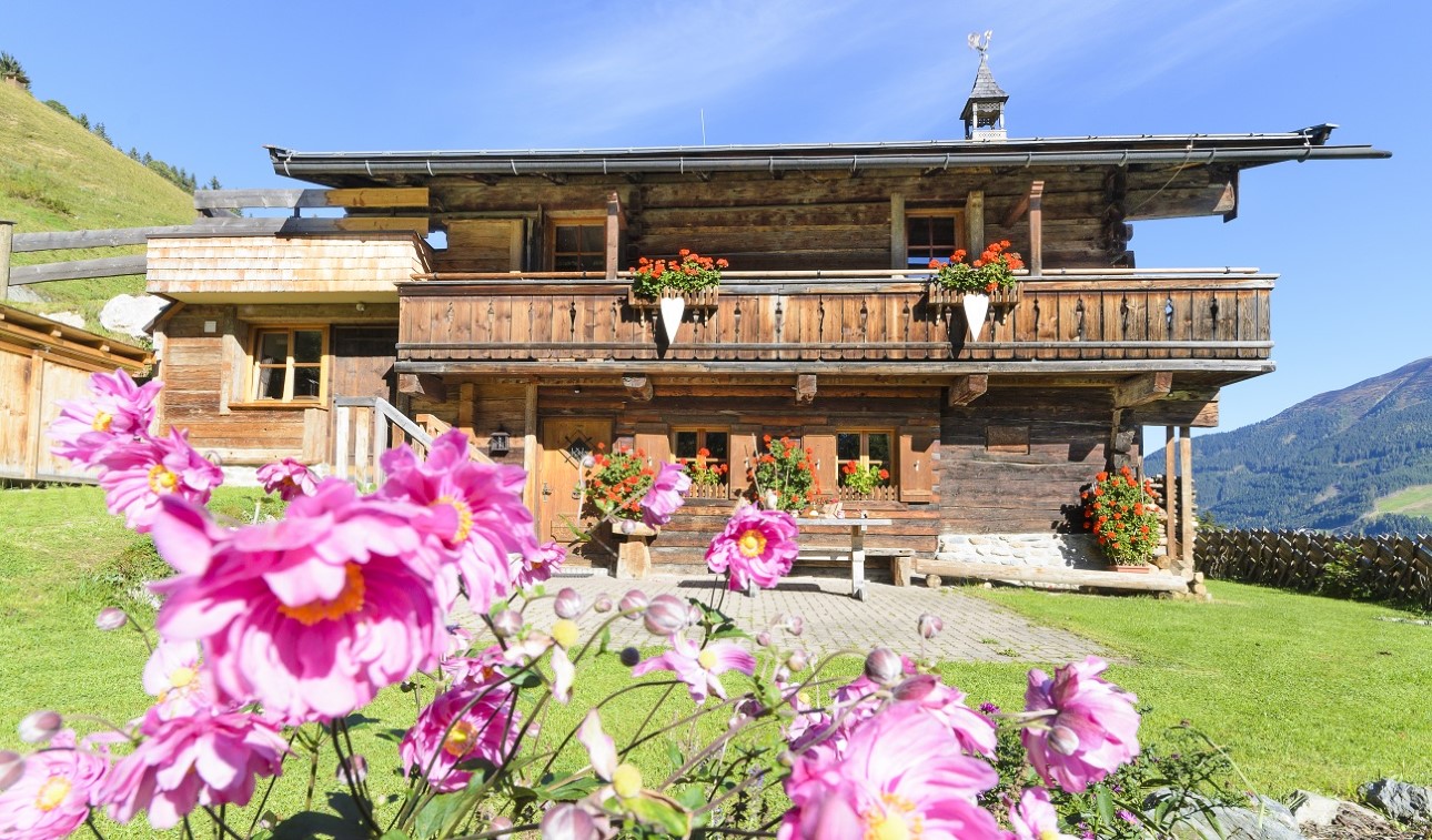 Mitterstall mit Blumengarten und Balkonen im Sommer